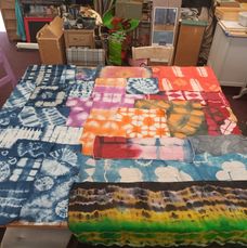 A Table covered in colourful Tie dyed pattern fabric samples